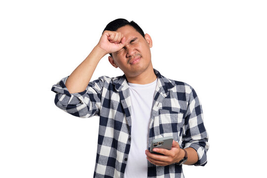 Forgetful young Asian man in casual shirt holding smartphone, trying to remember something isolated on transparent background