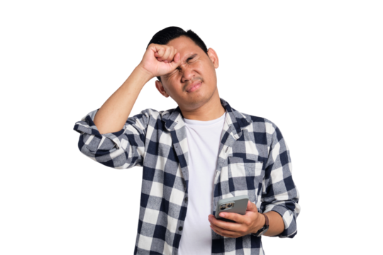 Forgetful young Asian man in casual shirt holding smartphone, trying to remember something isolated on transparent background
