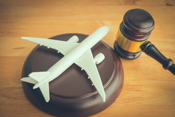 Judge hammer gavel and airplane on wooden table background. International Air Law (IAL), aviation law concept.