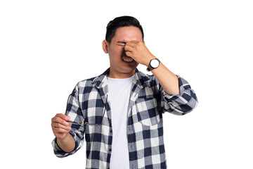 Tired young Asian man in casual shirt taking off glasses, feeling eye strain after work isolated on...
