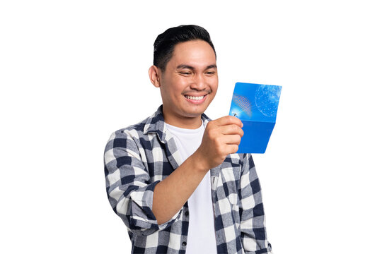Happy young Asian man in casual shirt looking at saving account passbook isolated on transparent background