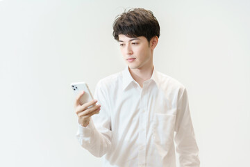 呆然とスマートフォンを見つめる男性
