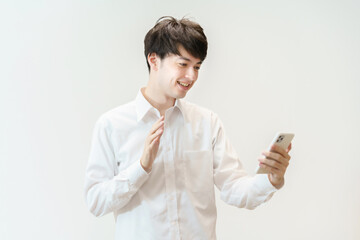 笑顔でスマートフォンに手を振る若い男性