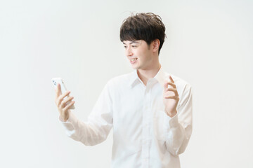 笑顔でスマートフォンに手を振る若い男性