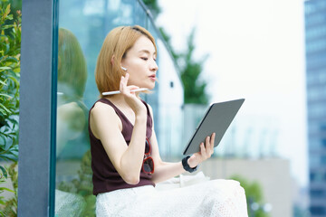 タブレットPCを使って、オンラインでコミュニケーションをする女性