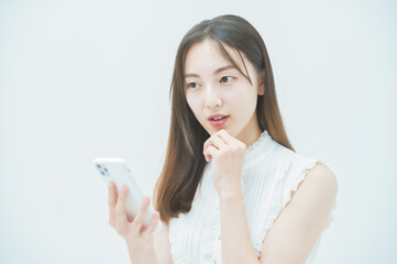 嫌な感情でスマートフォンを見る女性