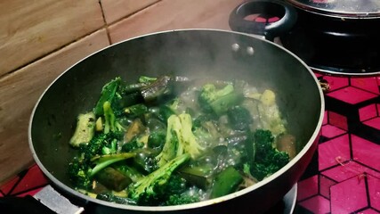Cooking green broccoli and green beans in a frying pan. Cooking video.
