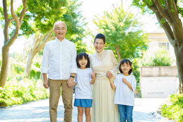 孫と一緒に散歩するシニア夫婦