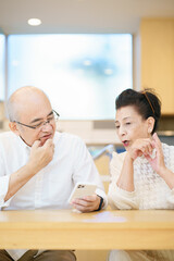 試行錯誤しながらスマートフォンを使うシニア夫婦