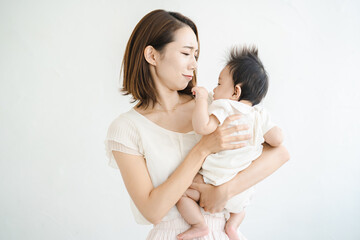 赤ちゃんを抱えて、疲れた表情をするお母さん