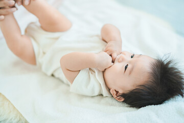 仰向けになって寝そべる赤ちゃん