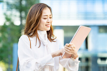 屋外でタブレットPCを使う女性