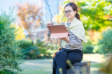 屋外でタブレットPCを使う女性