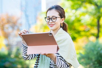 屋外でタブレットPCを使う女性