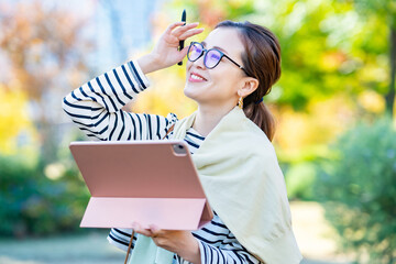 屋外でタブレットPCを使う女性
