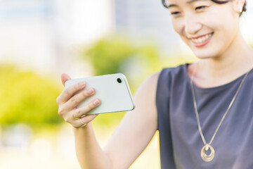 スマートフォンの画面を見る女性