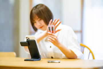 スマートフォンを使ってコスメグッズを紹介する女性