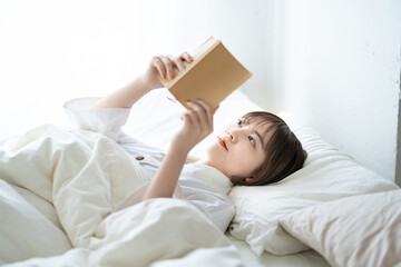 ベッドで本を読む女性