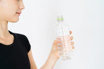 スポーツウェア姿で水分補給をする女性