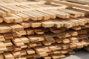 Stack of wooden boards used on the construction site. Construction material, building supplies,...