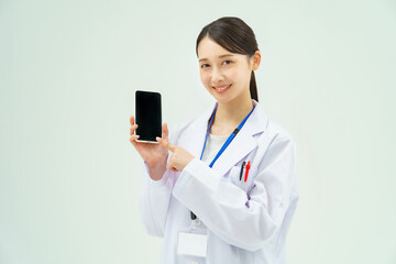 スマートフォンを持つ白衣の女性
