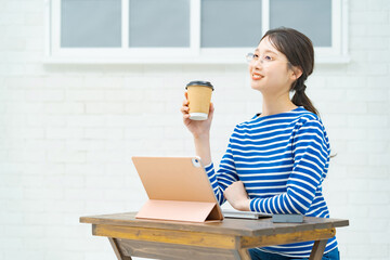 部屋でタブレットPCを操作する若い女性