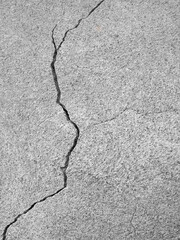 Thin winding deep crack on old gray concrete wall. Abstract image of vertical cleft. Several of...