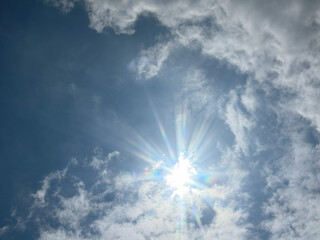 Blue sky background and white clouds soft focus image.  Natural sky with clouds and sun.
