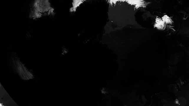 Black ink drops bleed and spread across a white background in an organic artistic transition, perfect for use as a reveal, background, or luma matte effect