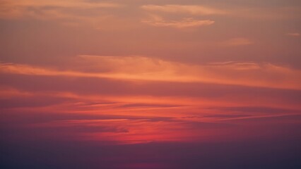 Magnificent sky at sunset painted in vibrant hues of orange, pink, and purple, with soft clouds drifting across the glowing horizon, creating a serene and breathtaking view of nature’s evening beauty