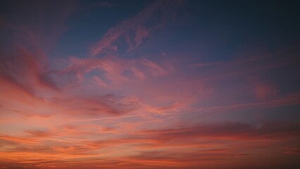 Magnificent sky at sunset painted in vibrant hues of orange, pink, and purple, with soft clouds drifting across the glowing horizon, creating a serene and breathtaking view of nature’s evening beauty