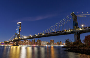 A panoramic sunset view of the Manhattan Bridge stretching towards Manhattan