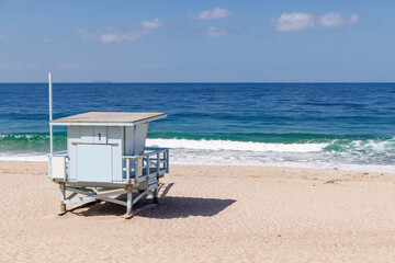 Lifeguard tower on a California ocean beach with golden sand and waves