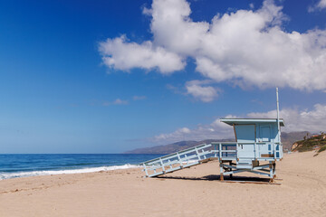 Lifeguard tower on a California ocean beach with golden sand and waves