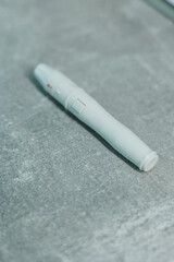 CloseUp of a White Microneedling Pen on a Textured Surface for Skincare Treatments and Aesthetic Procedures