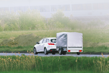 Car towing trailer during golden sunset drive