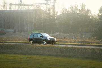 Family vehicle driving on rural road at sunset