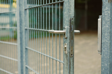 This is a closeup view of a robust metallic gate featuring a secure lock, which is presently in an...