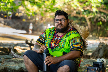 Local Costa Rican man in a Caribbean shirt relaxing on a tropical beach at Cahuita National Park in Costa Rica