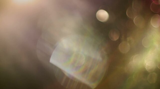 A seamless loop of a beautiful and soft bokeh light leak overlay, featuring gently shifting, out-of-focus purple and orange lights perfect for a dreamy, atmospheric background