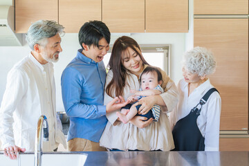 Smiling three-generation family surrounding a baby