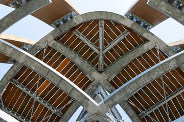 Detail of the top structure of the Tokaj observation tower near Malá Tŕňa, Slovakia. Steel and wood construction with visible beams, joints, and braces under clear sky.