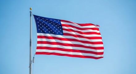 Obraz premium Waving American flag against clear blue sky stars and stripes
