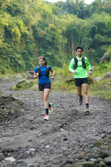 Asian Indonesian couple trail running outdoors, active sustainable lifestyle exercise