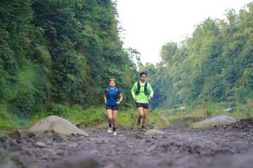 Asian Indonesian couple trail running outdoors, active sustainable lifestyle exercise