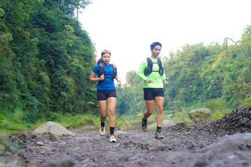 Asian Indonesian couple trail running outdoors, active sustainable lifestyle exercise