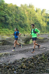 Asian Indonesian couple trail running outdoors, active sustainable lifestyle exercise