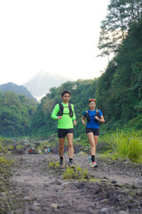 Asian Indonesian couple trail running near Merapi volcano, active sport and sustainable lifestyle