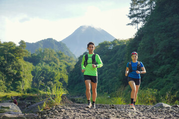 Asian Indonesian couple trail running near Merapi volcano, active sport and sustainable lifestyle