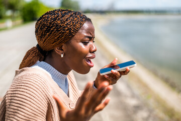 Young black woman is talking on the phone. She is anxious and worried.